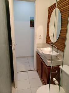 a bathroom with a sink and a mirror at Casa Oceano Azul in Guarujá
