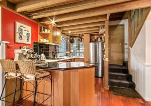 a kitchen with red walls and a counter with bar stools at Bogong Jacks in Dinner Plain