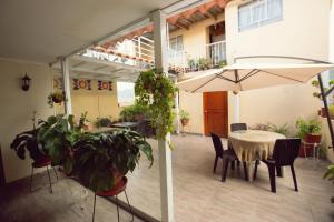 a patio with a table and chairs and an umbrella at Hospedaje Zaragoza in Ayacucho