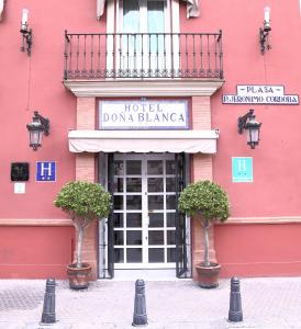 un edificio rosa con un cartel para un hotel dana blanca en Hotel Doña Blanca en Sevilla