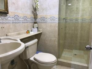 a bathroom with a toilet and a sink and a shower at Apartamento Alvarez in Cartagena de Indias +27 photos