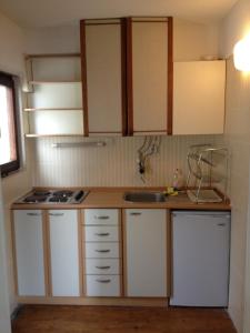 a small kitchen with white cabinets and a sink at Bilyana Apartments in Ohrid