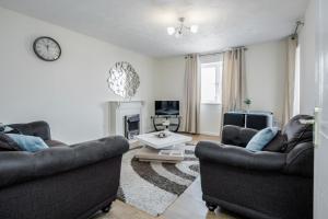 a living room with two couches and a table at Captivating 3-Bed Apartment in Grays in West Thurrock