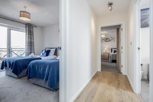a bedroom with two beds and a hallway at Captivating 3-Bed Apartment in Grays in West Thurrock