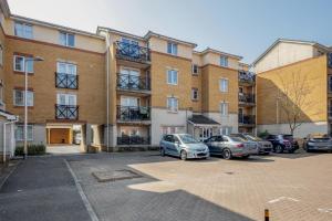 a parking lot with cars parked in front of a building at Captivating 3-Bed Apartment in Grays in West Thurrock