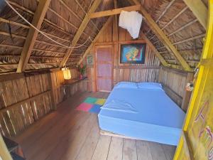 un lit dans une chambre avec un plafond en bois dans l'établissement Hakuna Matata Ecolodge, à El Valle