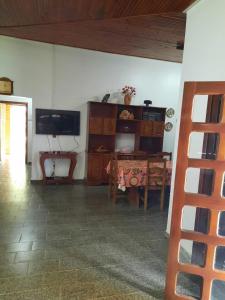 - un salon avec une télévision et une table à manger dans l'établissement Chácara Charbella, à Três Ranchos