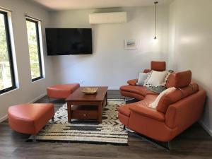 a living room with two couches and a tv at Gillys Guesthouse in Metung