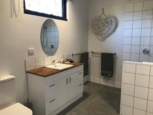bagno con lavandino, servizi igienici e specchio di Gillys Guesthouse a Metung
