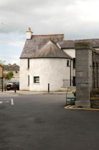 a white building with a roof on a street at Castletown Round House in Celbridge