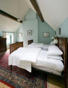a bedroom with a large bed with white sheets at Castletown Round House in Celbridge