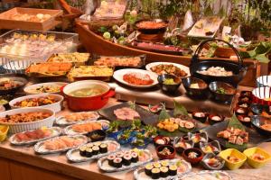 伊豆市にある湯めぐりの宿 修善寺温泉 桂川のテーブルの上に様々な種類の料理を揃えたビュッフェ