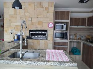 cocina con fregadero y encimera en Casa confortável com piscina en Tramandaí
