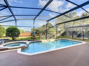 ein großer Pool in einem Gebäude mit Dach in der Unterkunft Triton Vacation Pool Home Near Disney in Orlando