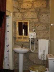 a stone bathroom with a sink and a mirror at Residencia Pedra Antiga in Porto