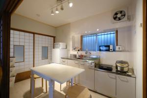 a kitchen with a table and a white refrigerator at Ichiya - Vacation STAY 83331 in Shimosato