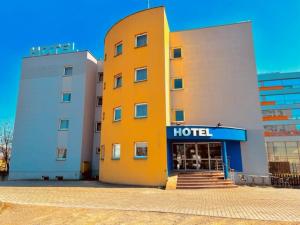 un hotel con un edificio amarillo al lado de un edificio en Hotel Major Budget, en Cracovia