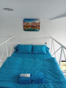 1 cama azul en un dormitorio con una foto en la pared en Baron Lighthouse Cottage & Eatery en Baron