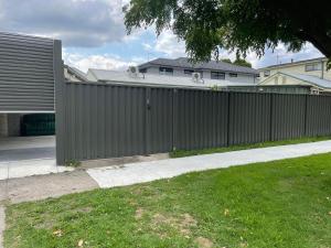 una cerca frente a una casa con un patio en Oakleigh Private unit en Oakleigh