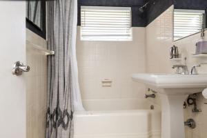 biała łazienka z umywalką, wanną i prysznicem w obiekcie Comfortable Home, 7 min Walk to Beach, Hot Tub, w mieście Pompano Beach