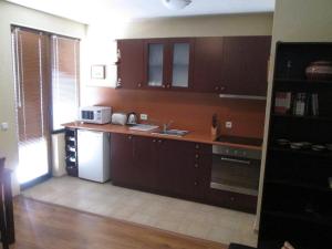 a kitchen with wooden cabinets and a counter top at Comfort Private Apartments in Bansko