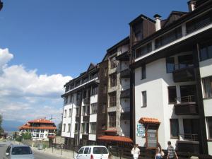 a group of buildings on the side of a street at Comfort Private Apartments in Bansko
