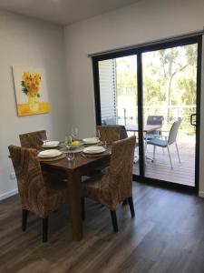 a dining room with a wooden table and chairs at Gillys Guesthouse in Metung