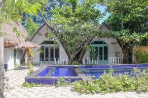 a villa with a swimming pool in front of a house at LUCKY'S in Gili Islands