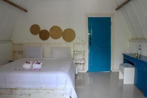 a bedroom with a white bed with two ducks on it at LUCKY'S in Gili Islands