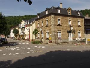 un gran edificio de ladrillo en una calle con una pasarela en Logis Hotel-Restaurant Dimmer en Wallendorf pont