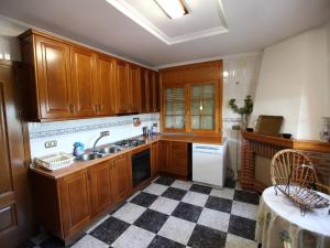 a kitchen with wooden cabinets and a checkered floor at Private villa en baza in Baza