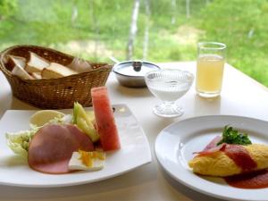 einen Tisch mit zwei Teller Essen und einem Obstkorb in der Unterkunft Ishinoyu Lodge in Yamanouchi