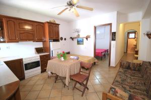 a kitchen and living room with a table and chairs at Villa Takis on Pelekas beach Apartment A with private garden and sea view in Pelekas +23 photos