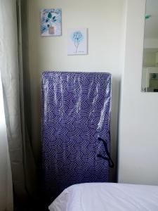 a blue and white pillow sitting next to a bed at SoSe's Crib at Mesaverte Garden Residences in Cagayan de Oro +11 photos