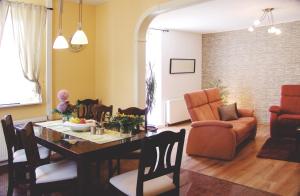 ein Wohnzimmer mit einem Esstisch und Stühlen in der Unterkunft Ferienhaus Landhaus Uttum in Krummhörn