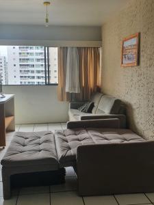 uma sala de estar com duas camas e um sofá em Flat Amplo em Boa Viagem em Recife