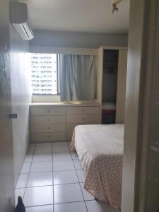 um pequeno quarto com uma cama e uma janela em Flat Amplo em Boa Viagem em Recife
