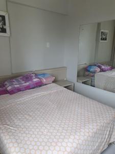 um quarto com duas camas e um espelho em Flat Amplo em Boa Viagem em Recife
