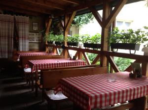 a restaurant with three tables with red and white checkered table cloth at Penzión Duna & soľná jaskyňa in Komárno