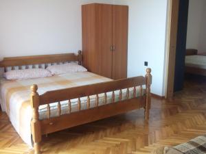 オパティヤにあるApartment Cameliaのベッドルーム1室(木製ベッド1台、木製キャビネット付)