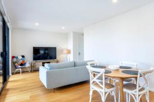 a living room with a couch and a table at Skypark on Vincent - EXECUTIVE ESCAPES in Perth