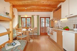 a kitchen with wooden ceilings and a table and chairs at Obermairhof in San Giacomo +16 photos