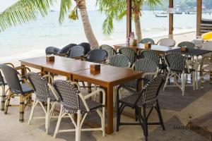 a row of tables and chairs at a restaurant on the beach at Samed Seaside Resort in Ko Samed