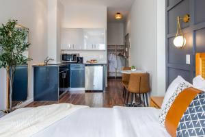 um quarto com uma cama e uma cozinha com armários azuis em The Modernist Hotel em Long Island City