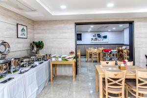 ein Restaurant mit Tischen und Stühlen und einer Theke in der Unterkunft Index Hotel J Dream Jeju in Jeju-do