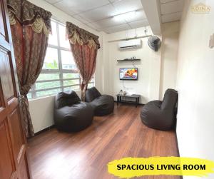 a living room with two chairs and a large window at Adina Homestay Langkawi ~Spacious Homestay~ in Kuah