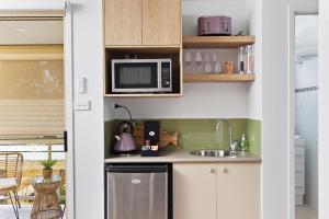 a kitchen with a sink and a microwave at HideAway on Tallean in Nelson Bay