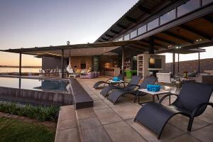a patio with chairs and a tv and a pool at Letlapa Metsi in Denysville