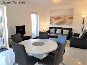 a living room with a white table and chairs at Ferienhaus Südwind Rhauderfehn, in Rhauderfehn