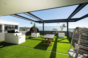 a patio with green grass and a table and chairs at Skypark on Vincent - EXECUTIVE ESCAPES in Perth
